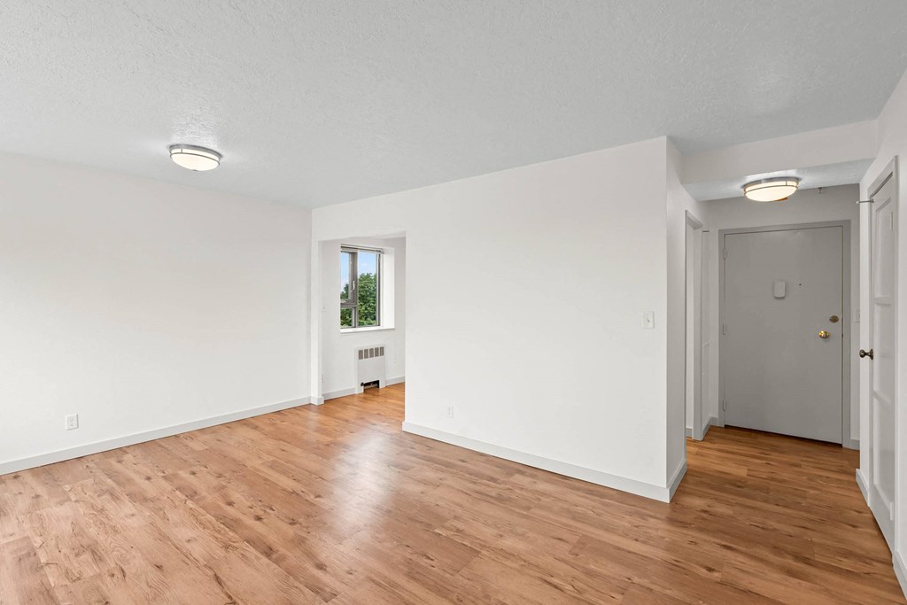 an empty living room with white walls and wood floors at Vista St. Clair, Portland, 97205