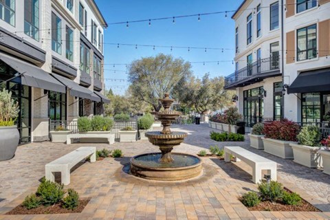 a courtyard with a fountain in the middle of buildings