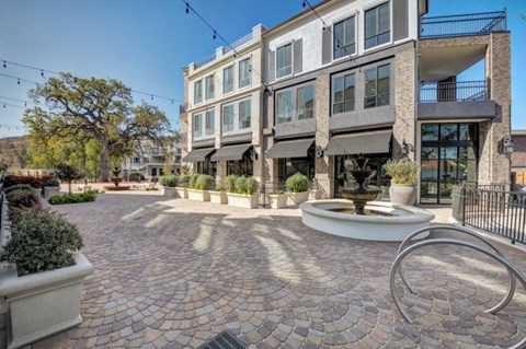 a courtyard with a fountain in front of a building