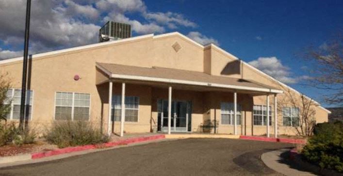 the front of a building with a street and a blue sky