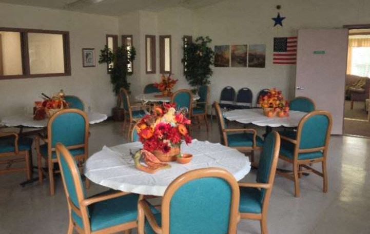 a dining room with tables and chairs and flowers