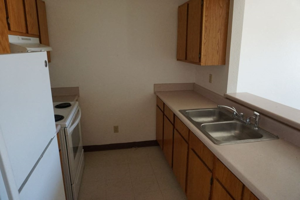 a kitchen with a sink and a stove and a refrigerator