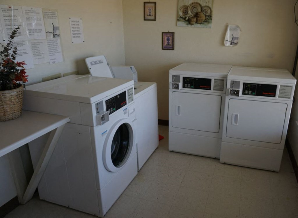 a row of washing machines and dryers in a laundry room