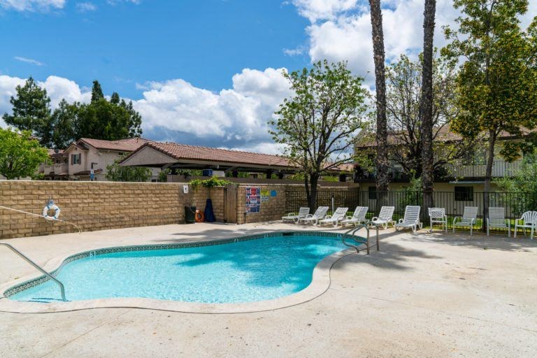 a swimming pool with chaise lounge chairs and a resort style pool