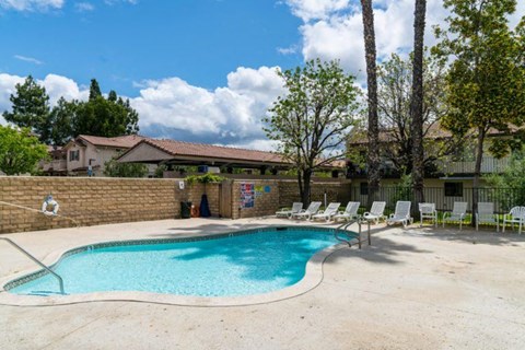 a swimming pool with chaise lounge chairs and a resort style pool