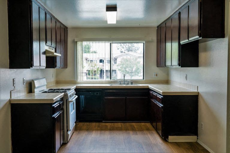 a large kitchen with a large window and wooden floors