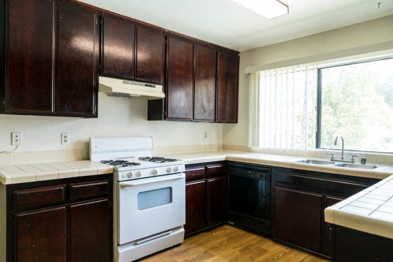 a kitchen with dark wood cabinets and white appliances