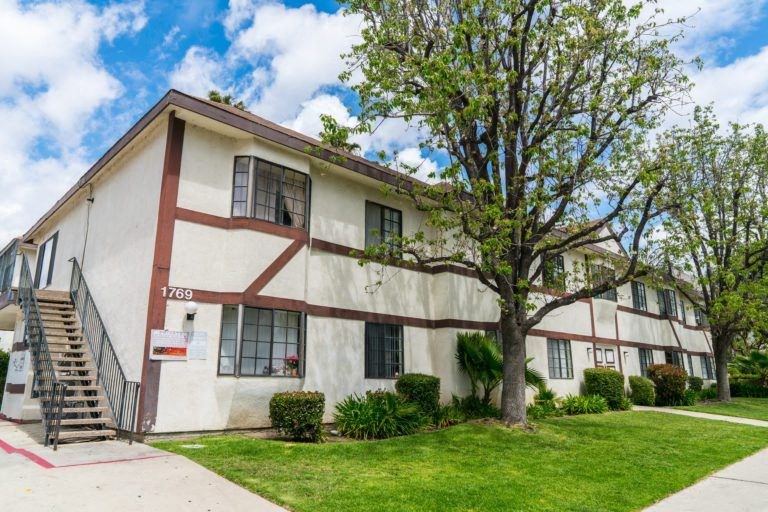 a white building with a tree in front of it