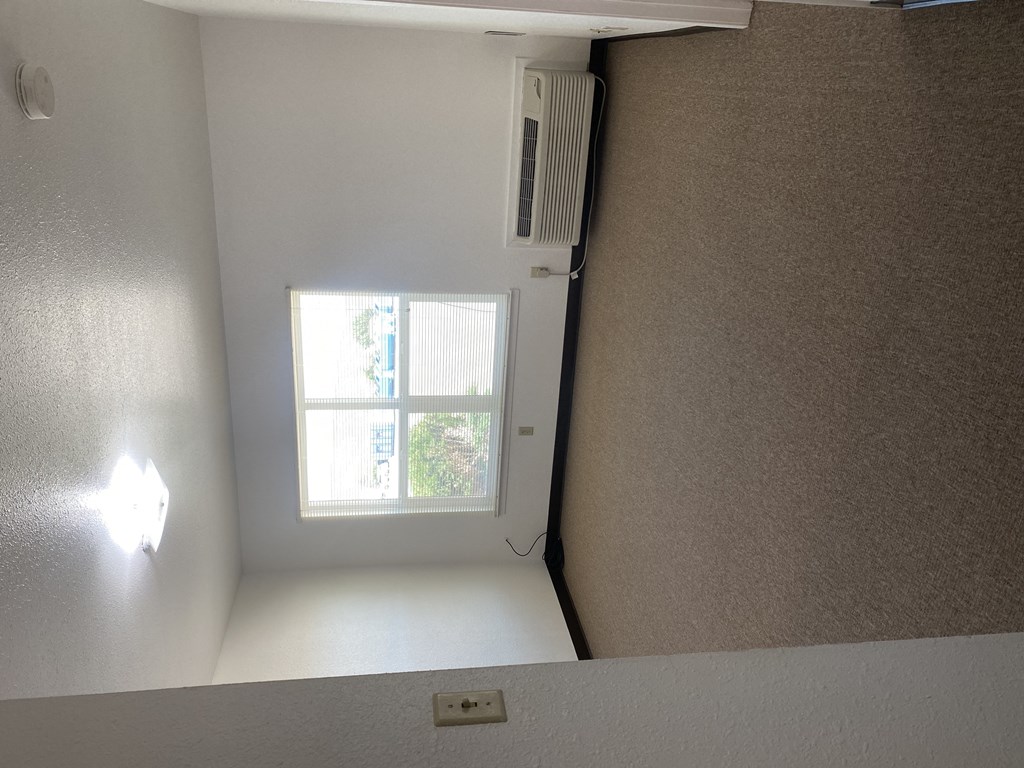 a window in a small room with a white wall and a window sill