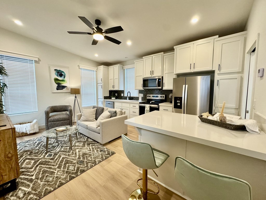 A modern kitchen with a white countertop and a ceiling fan.