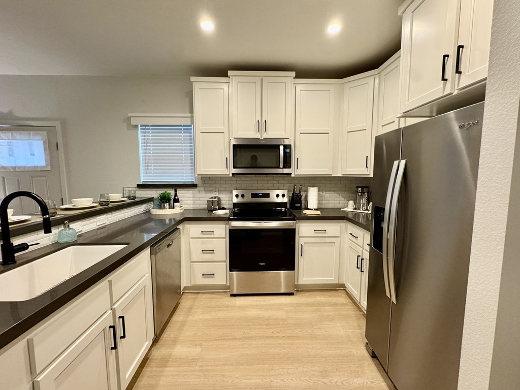 A kitchen with white cabinets and stainless steel appliances.