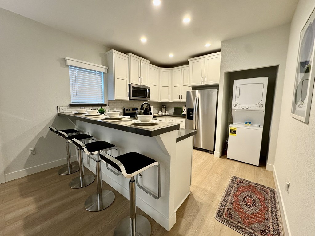 A kitchen with a refrigerator, microwave, and oven.