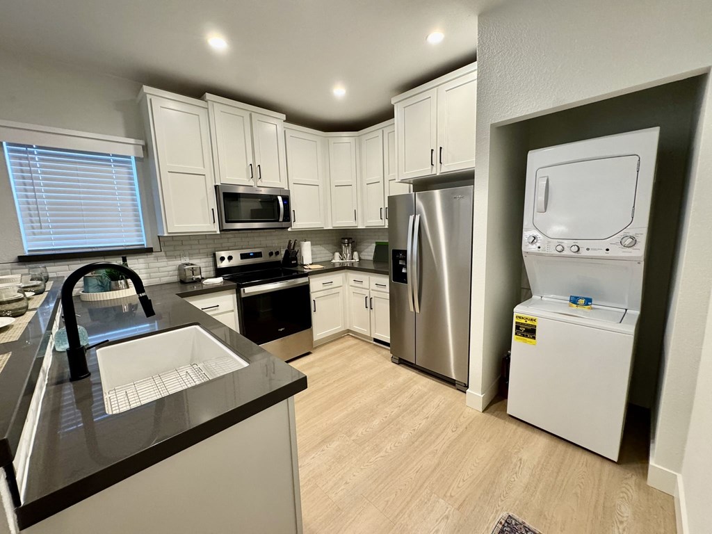 A kitchen with a sink, stove, and refrigerator.