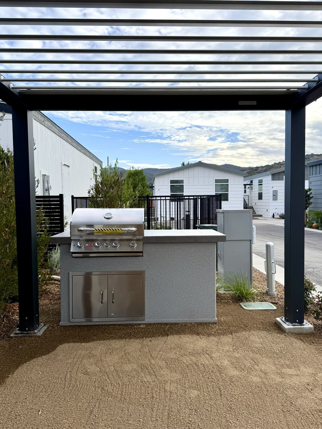 A stainless steel outdoor kitchen with a grill and sink.