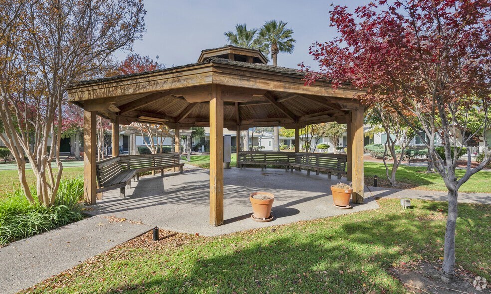 a gazebo with benches in a park