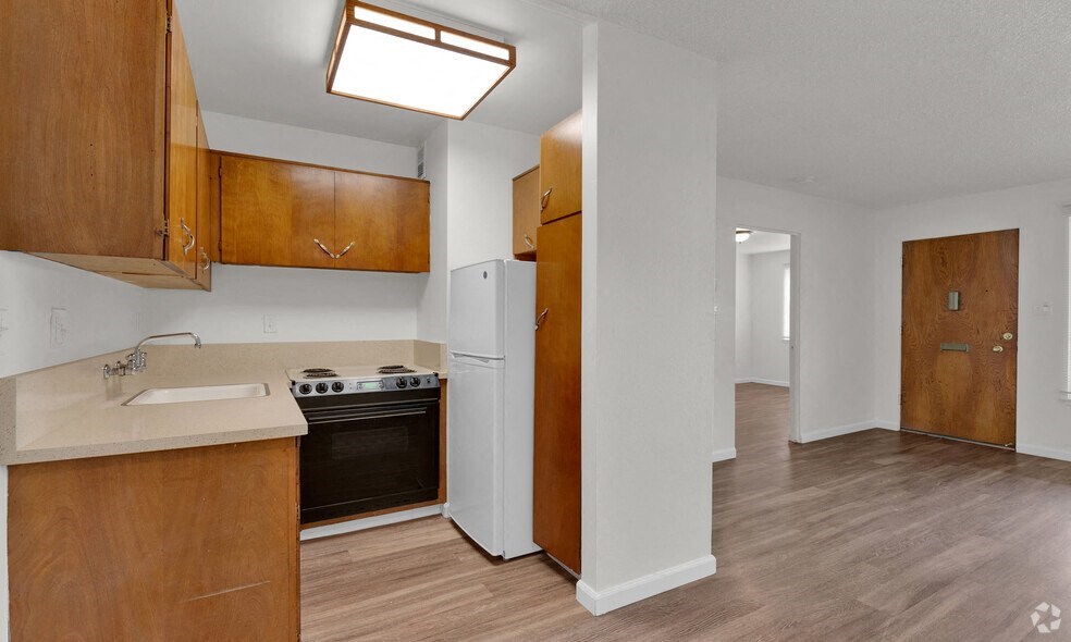 the view of a kitchen with a stove and a refrigerator