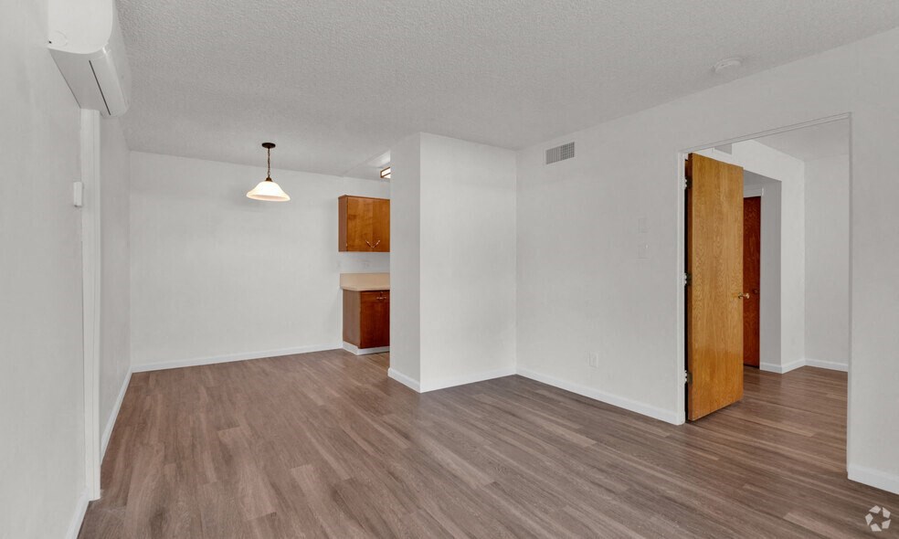 an empty living room with white walls and wood flooring