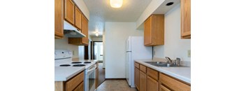 A kitchen with wooden cabinets and a white refrigerator.