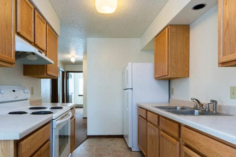 A kitchen with wooden cabinets and a white refrigerator.