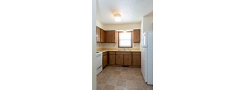 A kitchen with wooden cabinets and a white refrigerator.