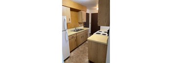 A kitchen with wooden cabinets and a white refrigerator.