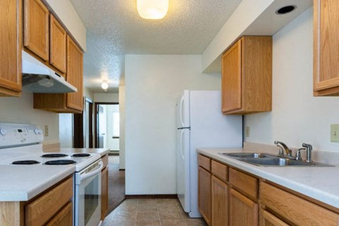 A kitchen with wooden cabinets and a white refrigerator.