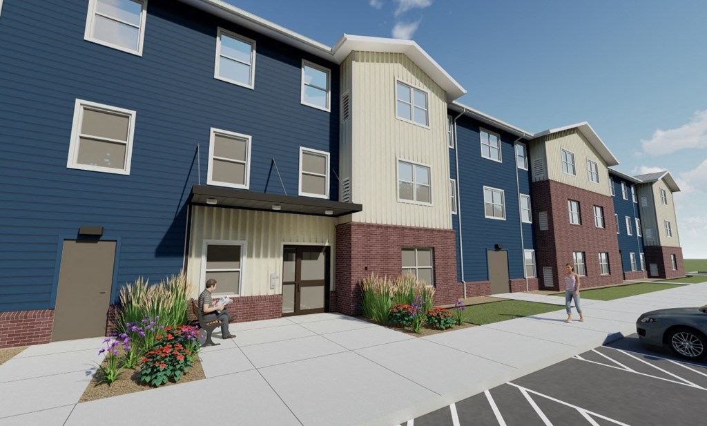 A blue building with a woman walking in front.