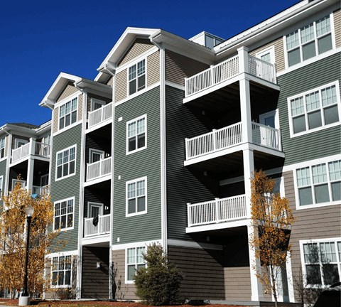 A large apartment building with balconies and multiple stories.