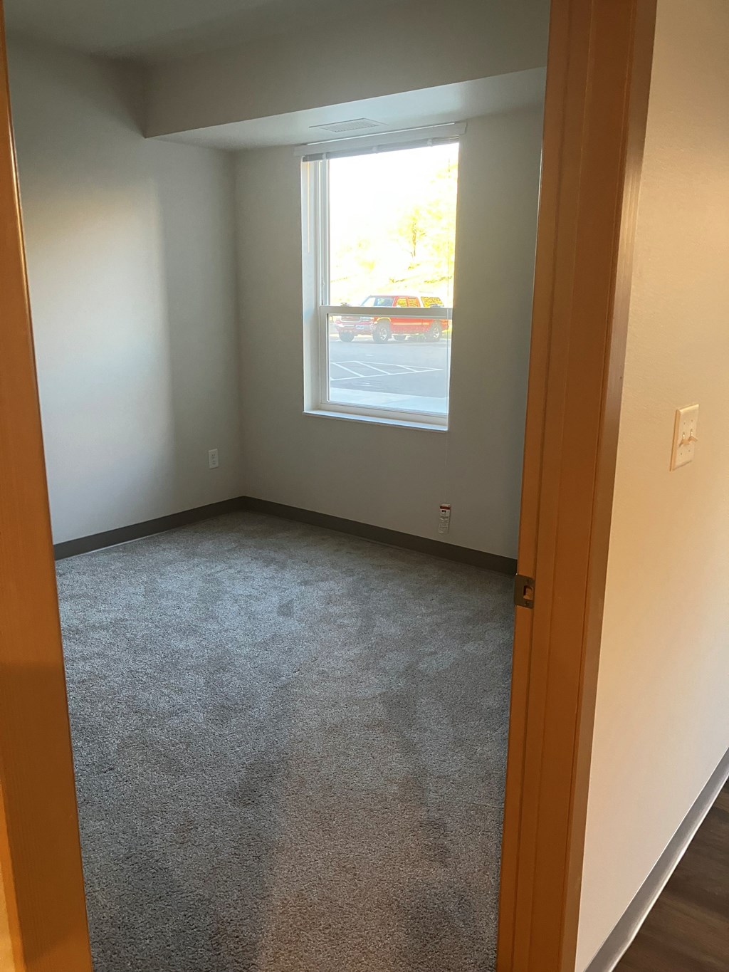 A room with a carpeted floor and a window.