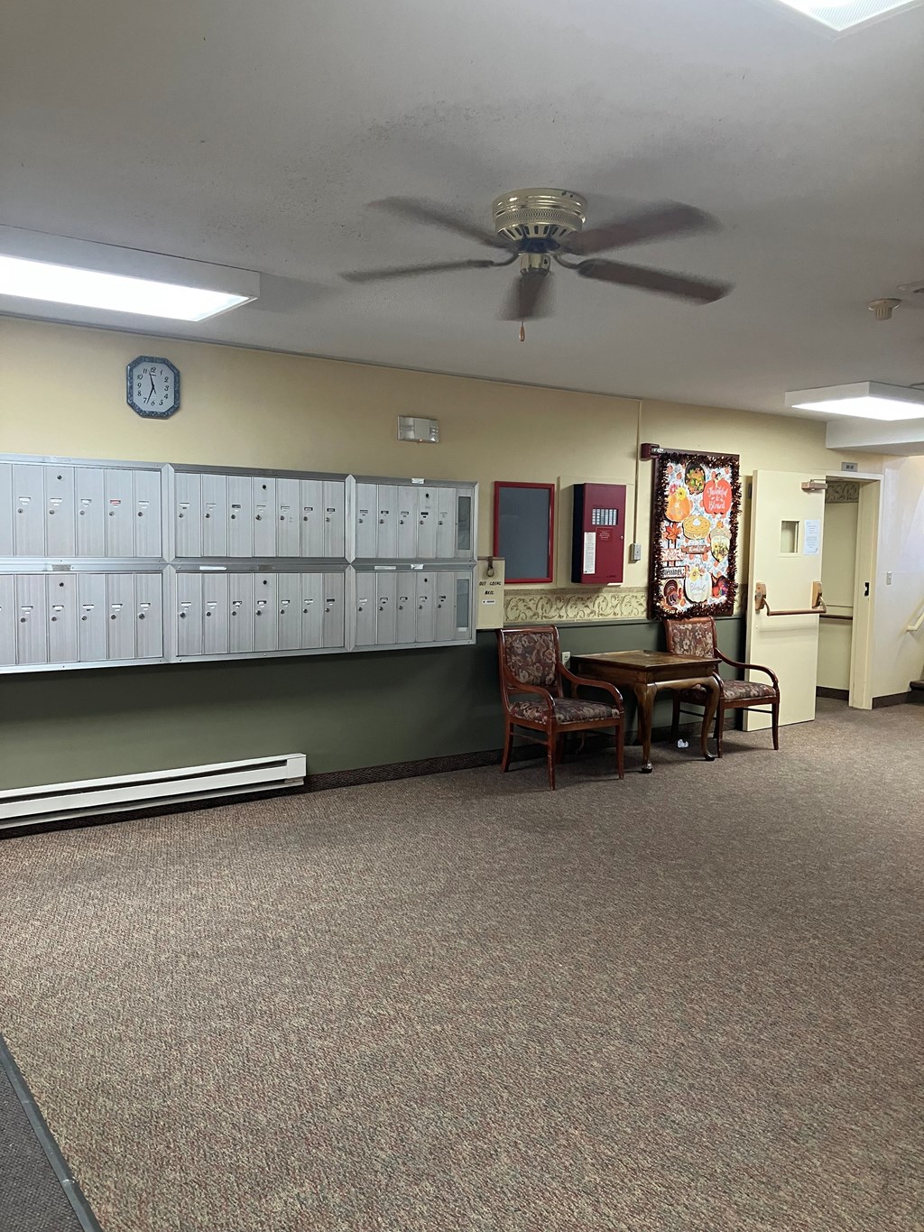 A room with a table and chairs and a fan.