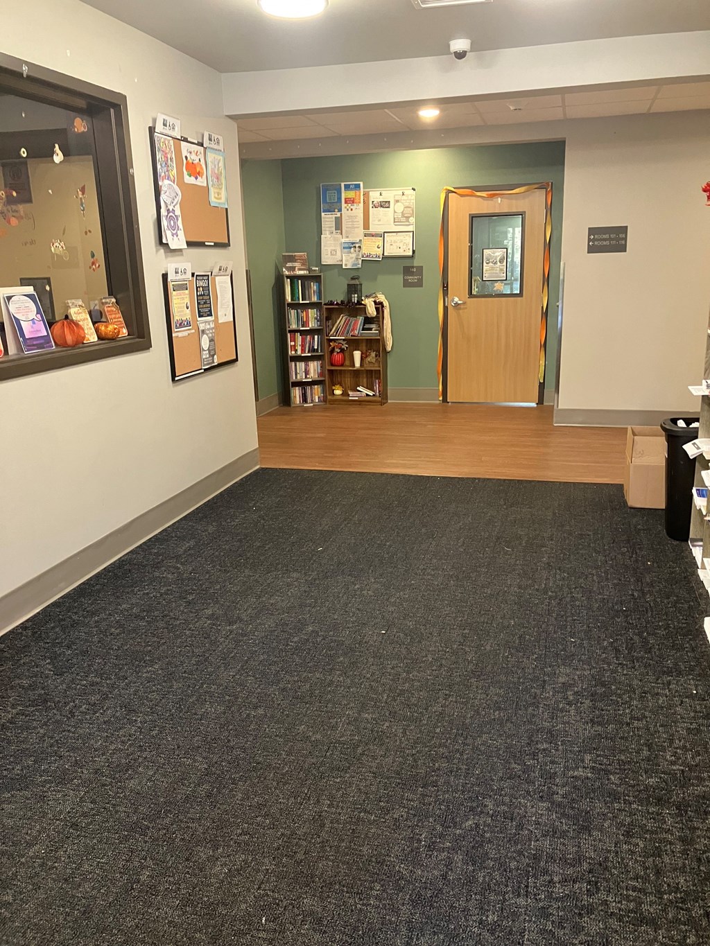 A room with a carpeted floor and a bookshelf.