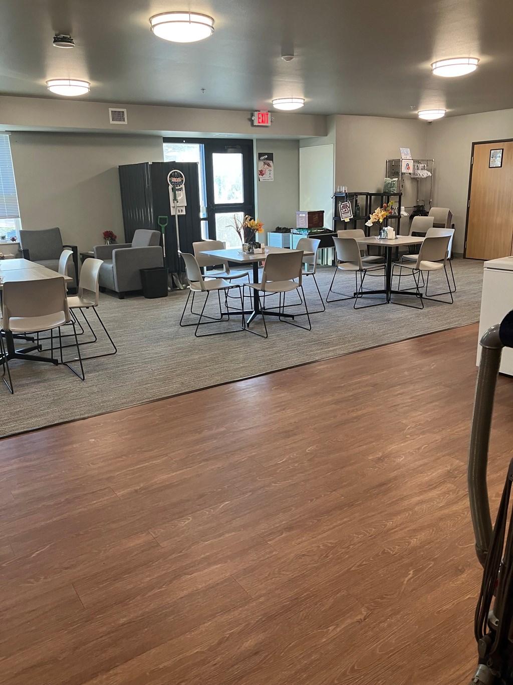 A room with a wooden floor and a table with chairs.