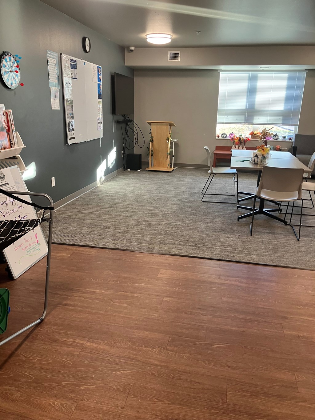 A conference room with a whiteboard and a clock on the wall.