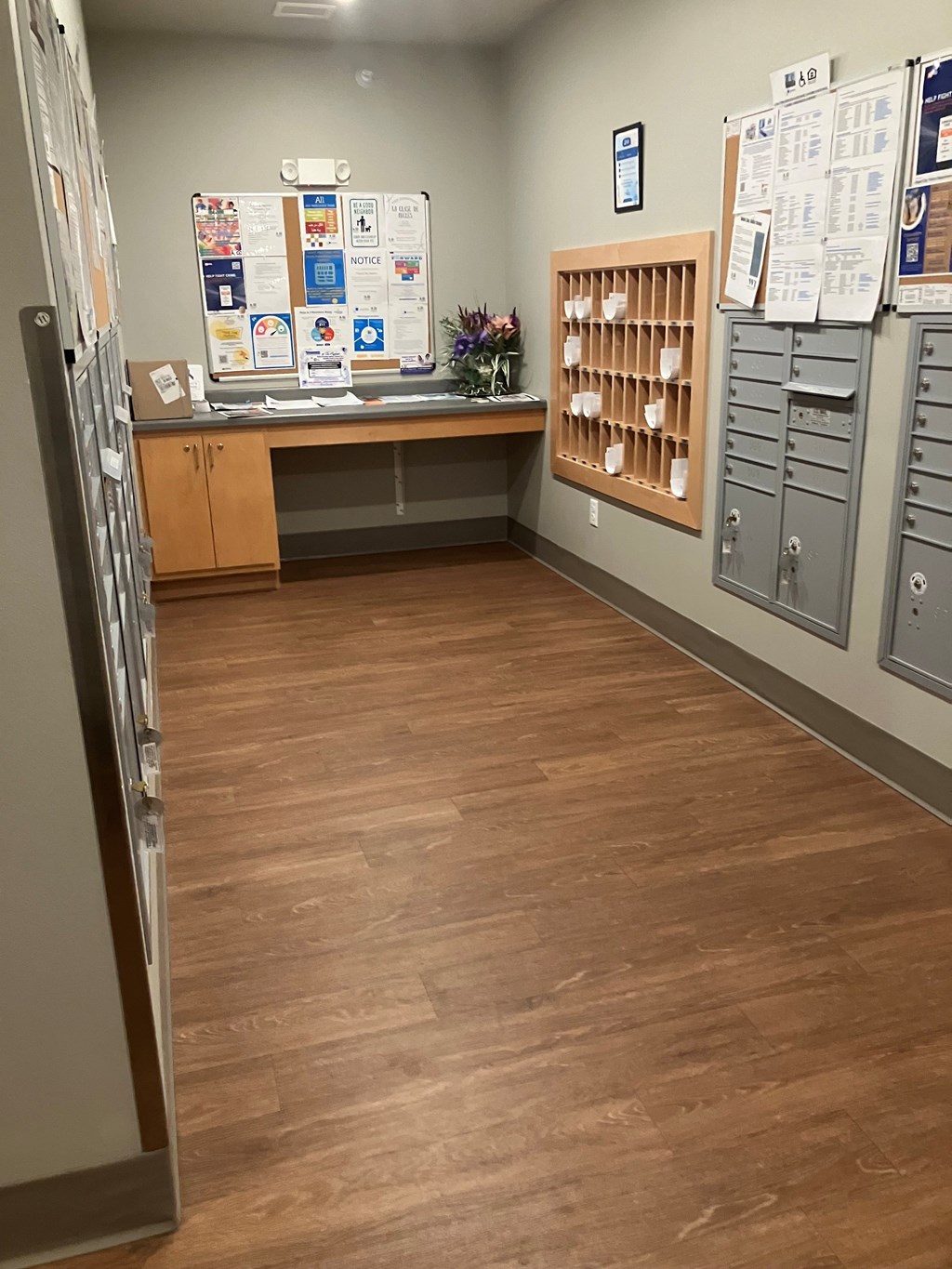 A room with a wooden floor and a whiteboard on the wall.