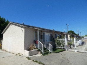 a small white house with a white fence