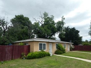 a small house with a yard and a fence