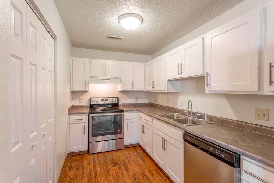 A kitchen with white cabinets and stainless steel appliances.