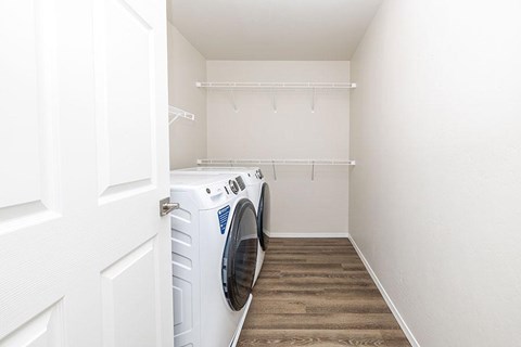 A white washing machine is in a small laundry room.