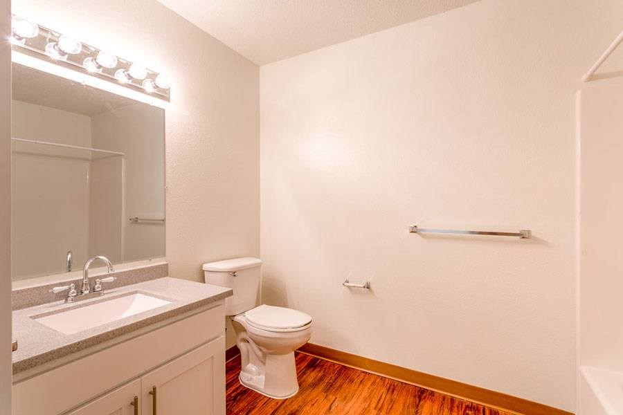 A white toilet sits in a bathroom next to a sink.