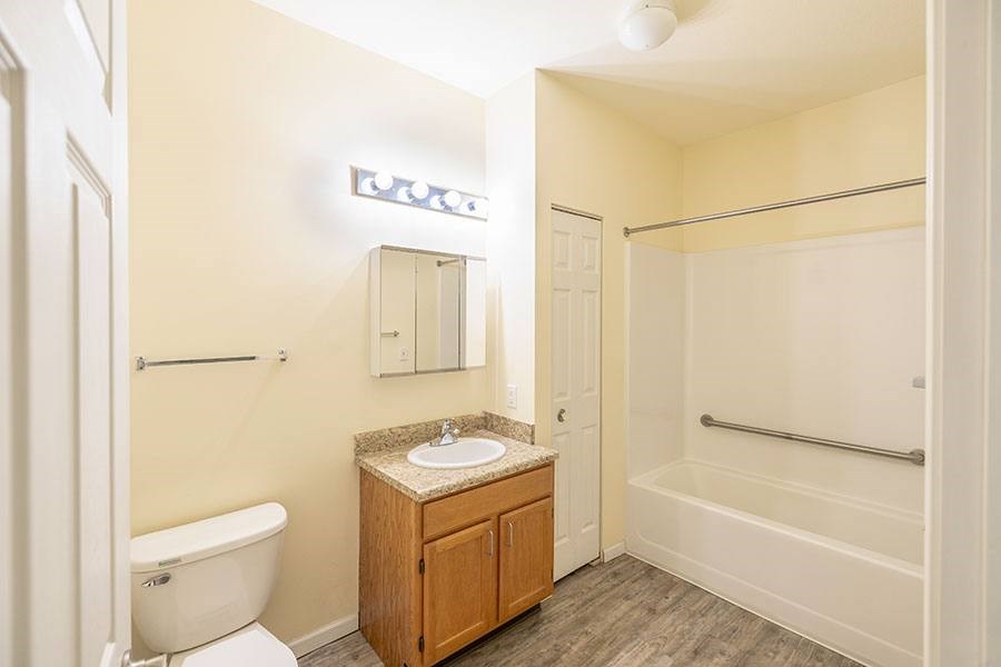 A bathroom with a white tub, sink, and toilet.