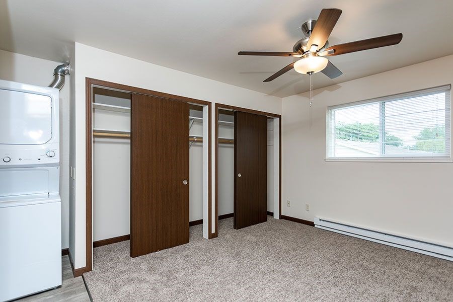 A room with a ceiling fan and a washer and dryer.