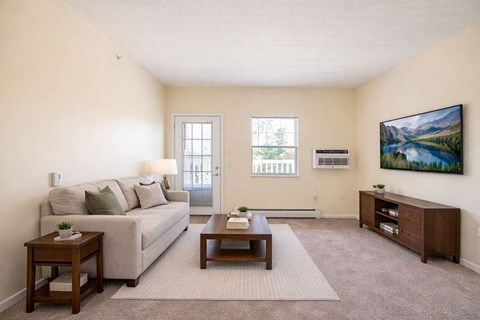 A living room with a couch, coffee table, and a painting on the wall.