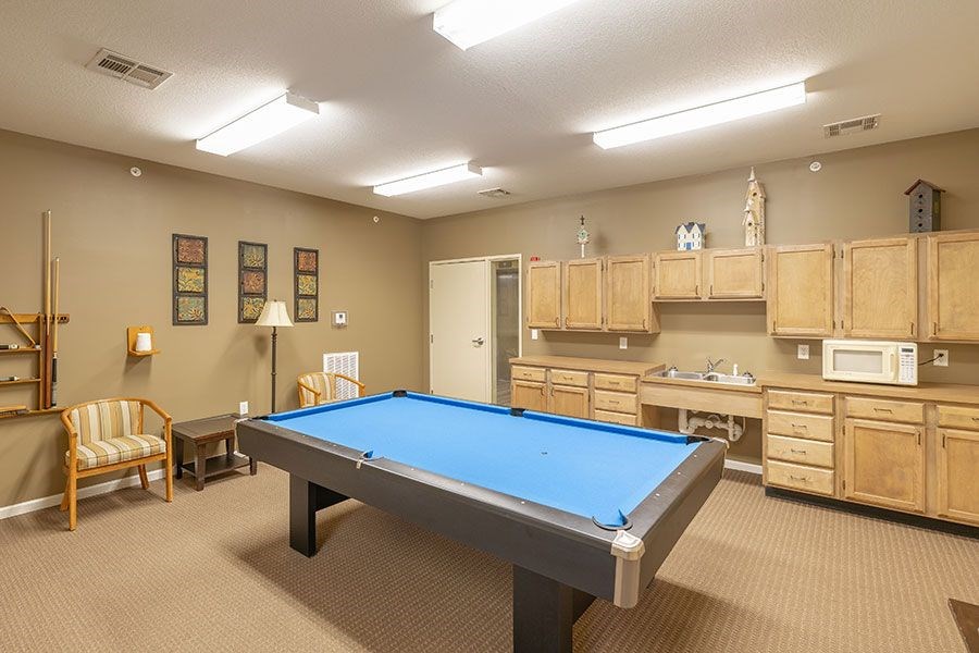 A room with a pool table and a chair.