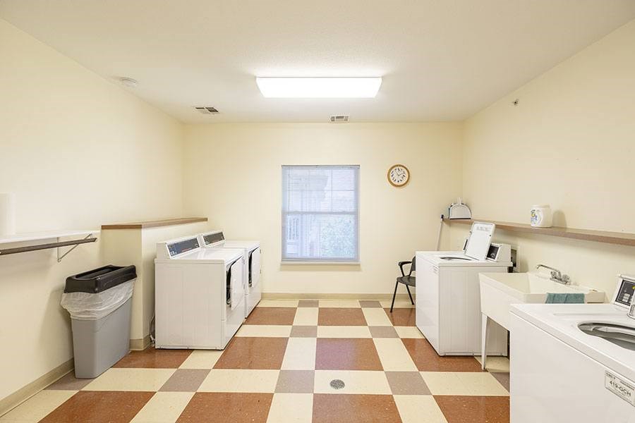 A laundry room with a washer and dryer, a sink, and a window.