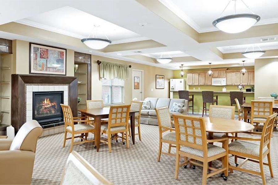 A living room with a fireplace and a dining table.