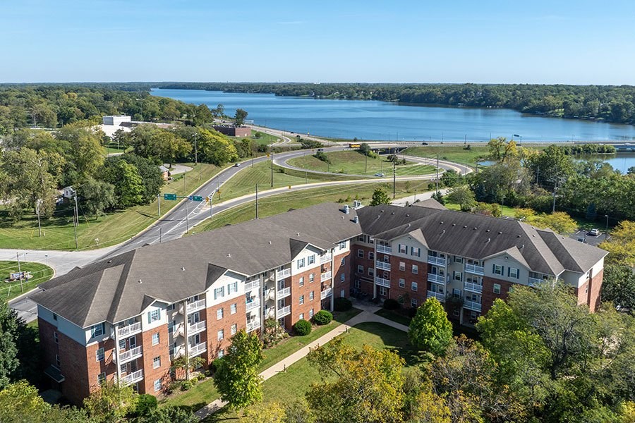 A large apartment complex with a lake in the background.