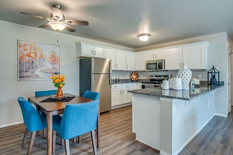 A kitchen with a table and chairs and a fridge.