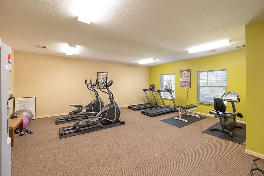 A gym with treadmills, elliptical machines, and other exercise equipment.