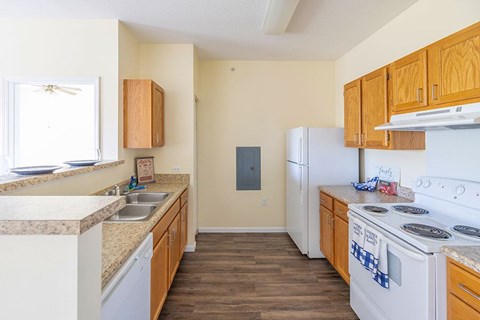 A kitchen with wooden cabinets and a white stove top oven.
