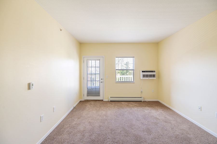 A room with a door, window, and air conditioner unit.